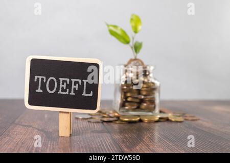 TOEFL - Wörter aus Holzblöcken mit Buchstaben, der Test des Englischen als Fremdsprache, TOEFL-Konzept, weißgrauer glänzender Hintergrund mit Reflexion Stockfoto