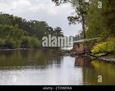 Einstürzende verlassene Hütte am Ufer in ruhigem Wasser des Bayou des Atchafalaya Basin in der Nähe von Baton Rouge Louisiana Stockfoto