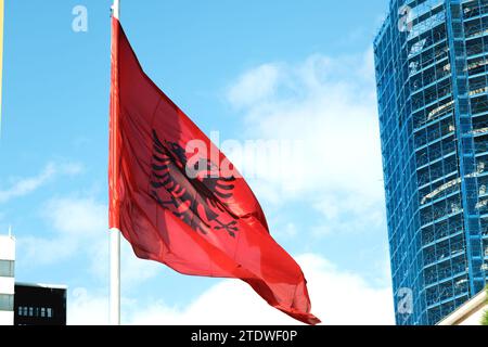 Große albanische Flagge flattert im Wind vor einem klaren blauen Himmel und symbolisiert nationalen Stolz und Erbe Stockfoto