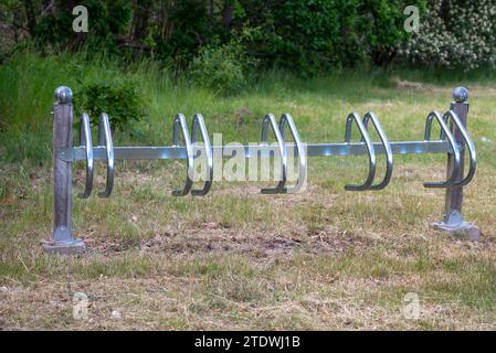 Radträger aus grauen Blechrohren in Form eines Rechtecks auf dem Rasen, Pflaster aus Granitwürfeln in der Stadt, Schotter, Parkweg Stockfoto