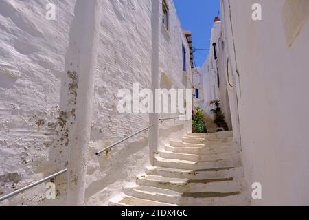 Pyrgos, GR - 6. August 2023: Straße in einem traditionellen griechischen Dorf mit weiß getünchten weißen und blauen Häusern Stockfoto
