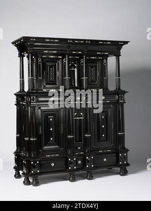 Schrank, anonym, ca. 1630 - ca. 1640 Schrank mit Ebenholz verklebt und mit Elfenbein auf einem Eichenkern dekoriert. Die Möbel bestehen aus einem oberen und einem unteren Gehäuse. Die Stile sind mit toskanischen Halb-Kolonetten dekoriert. Im Unterschrank auf beiden Seiten einer Nische mit Kissen, dekoriert mit elfenbeinfarbenen Kappen. Das Fenster ist mit Diamantköpfen und Speck dekoriert. Drei Schubladen in der mittleren Linie und am Fuß. Der Oberschrank springt zurück, hat zwei Türen und ein Medium und wird entsprechend dem Unterschrank behandelt. Die Möbel liegen auf Birnenförmigen Glühbirnen. Amsterdam (möglicherweise) Holz (Pflanzenmaterial). Eiche (Holz). Stockfoto