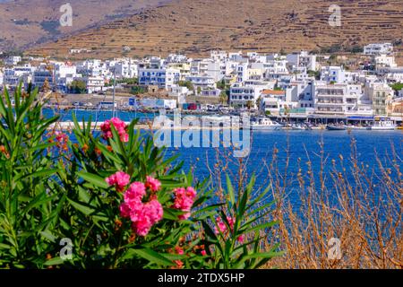 Tinos, GR - 6. August 2023: Panoramablick auf Chora, Hauptstadt der Insel Tinos, mit Bougainvillea im Vordergrund Stockfoto