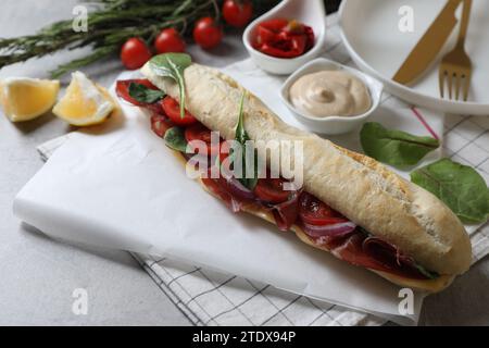 Köstliches Sandwich mit Bresaola auf hellgrauem Tisch Stockfoto