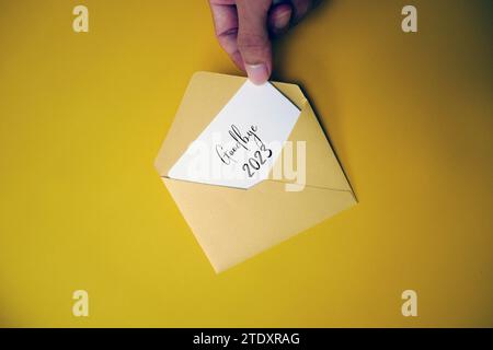 Ein Umschlag und ein Stück Papier mit den Worten Danke 2023. Auf Wiedersehen 2023, willkommen 2024. Vielen Dank 2023. Stockfoto