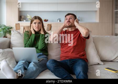 Gestresstes, unglückliches Paar, das unter lauten Nachbarn leidet. Nachteile des Wohnens im Wohnhaus Stockfoto