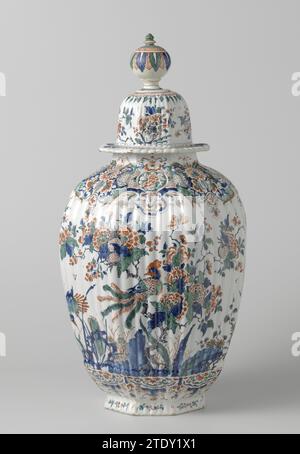 Achteckige Rippenvase aus vielfarbig bemalter Faienz, der Metalltopf, nach Lambertus van Eenhoorn, um 1695 - um 1725 achteckige, geriffelte Vase aus mehrfarbig gemalter Faienz. Die Vase ist mit Blumen, Felsen, Vögeln und einem Vogel in einem Baum bemalt. Die Vase ist Teil eines Paares, die anderen Teile sind: Zwei dieser Töpfe mit gleichen Töpfen und zwei identische Vasen. Die Teile sind markiert. Delfter Steingut. Zinnglasur. Achteckige, geriffelte Vase aus mehrfarbig bemalter Faienz. Die Vase ist mit Blumen, Felsen, Vögeln und einem Vogel in einem Baum bemalt. Die Vase ist Teil eines Paares, die anderen Teile sind: Zwei von diesem Topf Equa Stockfoto