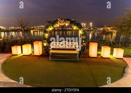 Wunderschöne romantische Bank mit Licht am Abend. Stockfoto
