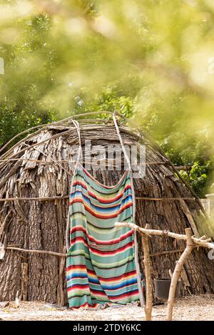 Topeka, Kansas, USA - 17. Juni 2023: Nachmittags scheint Sonnenlicht auf ein rekonstruiertes Wigwam und einheimisches Plains Dorf in der Old Prairie Town in Ward-MEA Stockfoto