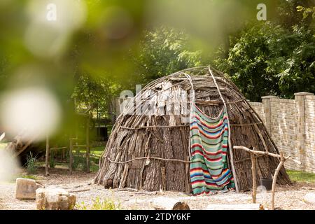 Topeka, Kansas, USA - 17. Juni 2023: Nachmittags scheint Sonnenlicht auf ein rekonstruiertes Wigwam und einheimisches Plains Dorf in der Old Prairie Town in Ward-MEA Stockfoto