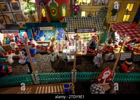 Coburg, Deutschland. Dezember 2023. Zwischen den Verkaufsständen eines Modellweihnachtsmarktes herrscht viel Trubel. Rund 20 Meter vom Coburger Marktplatz entfernt, hat der ausgebildete Sozialarbeiter und jetzt Rentner Horst Gründel eine einzigartige, detailreiche Winterwelt geschaffen. In einem Raum in seiner Wohnung befindet sich ein kleiner Weihnachtsmarkt mit einer Größe von etwa acht Quadratmetern. Über 30 Stände, eine Modelleisenbahn, vier Krippen, eine Gondel, ein Karussell und vieles mehr beleben die Landschaft. Gründel begann in den 1970er Jahren mit dem Bau der ersten Verkaufsstände Quelle: Pia Bayer/dpa/Alamy Live News Stockfoto