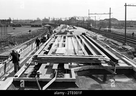 Bau des nördlichen Teils des westlichen Randweges zwischen der Bahn und Kleverlaan. Bau von Hochgleis und Viadukten über die neue Straße, Haarlem, Westelijke Randweg, Niederlande, Whizgle News aus der Vergangenheit, zugeschnitten auf die Zukunft. Erkunden Sie historische Geschichten, das Image der niederländischen Agentur aus einer modernen Perspektive, die die Lücke zwischen den Ereignissen von gestern und den Erkenntnissen von morgen überbrückt. Eine zeitlose Reise, die die Geschichten prägt, die unsere Zukunft prägen. Stockfoto