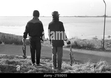 Zwei junge Männer, die Eis auf dem IJsselmeer sehen. Dezember 1962 Stockfoto