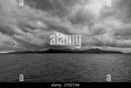 Eine schwarz-weiße Landschaft der Insel Elba unter einem bewölkten und stürmischen Himmel Stockfoto