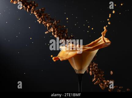 Espresso Martini-Getränk mit Spritzern und fallenden Kaffeebohnen auf schwarzem Hintergrund. Kopierbereich. Stockfoto