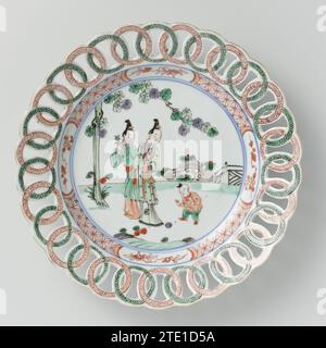 Teller mit zwei Frauen und einem Jungen im Garten, Rand aus ineinander greifenden offenen Ringen, ca. 1700 - ca. 1724 Porzellanplatte mit einem Rand aus durchbrochenen Zwischenringen, bemalt in unterschwelliger Glasur blau und auf der Glasur blau, rot, grün, Auberginen, schwarz und Gold. Auf der Wohnung zwei Frauen (lange Lippen) und ein Junge (verrückt) in einem umzäunten Garten an einem Baum; die Mauer mit geometrischem Muster durchsetzt mit einem prunus-Zweig in einer Kartusche; am Rand kräuseln. Rand wurde kaputt. Famle Verte. Porzellan. Glasur. Kobalt (Mineral). Gold (Metall) Malerei / Vergoldung / Verglasung Porzellanplatte mit einem Rand o Stockfoto