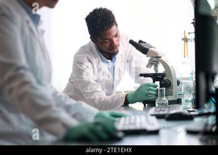 Männlicher Labortechniker, der Proben für die Mikroskopuntersuchung vorbereitet Stockfoto
