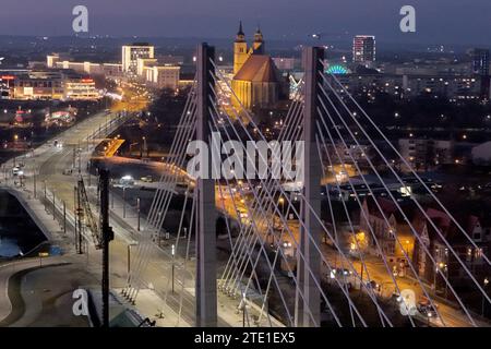 Magdeburg, Deutschland. Dezember 2023. Blick auf die neue Pylonbrücke über die alte Elbe bei Dämmerung (mit Drohne aufgenommen). In Magdeburg wird die neue Elbbrücke noch vor Weihnachten eröffnet. Auch die neue Brücke über die Alte Elbe und die Zollelbe ist bereits in Betrieb, zumindest für Straßenbahnen. Quelle: Peter Gercke/dpa-Zentralbild/dpa/Alamy Live News Stockfoto