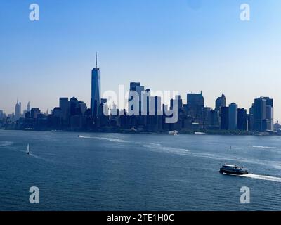 Die Skyline von New York City vom Sockel der Freiheitsstatue aus gesehen, wo die Wolkenkratzer des Big Apple und Manhattan zu sehen sind. Stockfoto