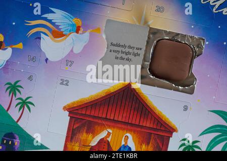 Öffnen Sie die Tür zum Weihnachtskalender mit Schokolade und einem Teil der Krippengeschichte Stockfoto