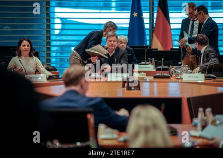 Berlin, Deutschland. Dezember 2023. Robert Habeck (M, Bündnis 90/die Grünen), Bundesminister für Wirtschaft und Klimaschutz und Vizekanzler, eröffnet in Abwesenheit der Bundeskanzlerin die Sitzung des Bundeskabinetts, neben Annalena Baerbock (Bündnis 90/die Grünen), Außenminister Wolfgang Schmidt (r, SPD), Leiter des Bundeskanzleramtes, und Christian Lindner (Front, FDP), Bundesfinanzminister. Der Bundeskanzler konnte wegen Krankheit nicht an der Sitzung teilnehmen. Quelle: Kay Nietfeld/dpa/Alamy Live News Stockfoto