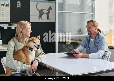 Tierarzt und Hundebesitzer haben ein positives Gespräch während des Checkout in der Klinik Stockfoto