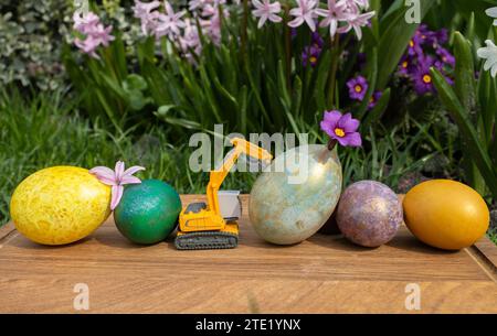 Modell eines Spielzeugbaggers mit hellen, bunten Eiern. Stockfoto