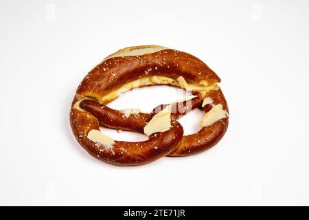 Deutsche Brezel mit Butter und Salz isoliert auf weißem Hintergrund. Stockfoto