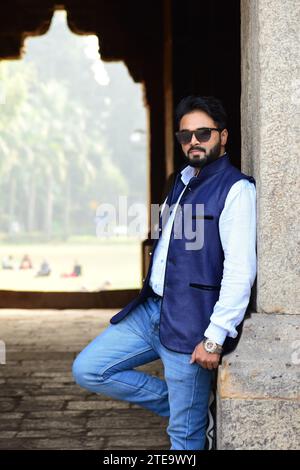 Die trendige junge indische Männlichkeit posiert selbstbewusst in einer stylischen schwarzen Sonnenbrille. Moderner Street Style, Ethnische Vielfalt, Kulturelle Identität, Schönes Modell Stockfoto