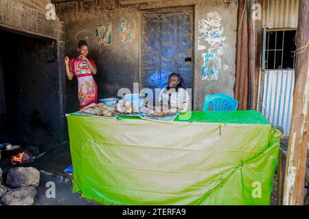 Junge Frauen verkaufen gebratenes Huhn in Kibera Slum, Nairobi. Ein Blick durch den Alltag in Kibera, dem derzeit größten Slum Afrikas, und den Tag danach Stockfoto