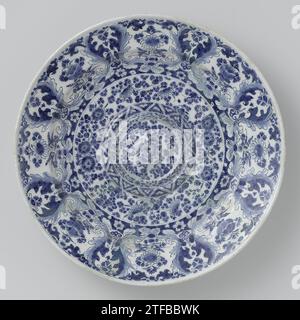 Lampet Dish, de Metaale Pot, nach Lambertus van Eenhoorn, ca. 1700 - ca. 1720 Runde Schale FUNUNUCE in blau bemalt, mit Kreisen im Relief mit bestreuten Blumen und acht Fächern mit Blumen am Rand. Die Schüssel ist auf der Rückseite markiert. Delfter Steingut. Zinnglasur. Runde Schale FUNUNUCE blau lackiert, mit Kreisen im Relief mit bestreuten Blumen und acht Fächern mit Blumen am Rand. Die Schüssel ist auf der Rückseite markiert. Delfter Steingut. Zinnglasur. Stockfoto