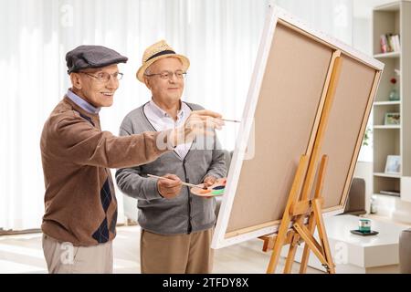 Ältere Männer malen auf Leinwand in einem Zimmer Stockfoto