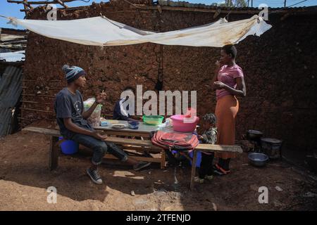 Die Einheimischen nehmen ihr Frühstück in einem offenen Mini-Restaurant in Kibera Slum, Nairobi, ein. Ein Blick durch den Alltag in Kibera, dem heutigen afrikanischen Stadtteil L Stockfoto