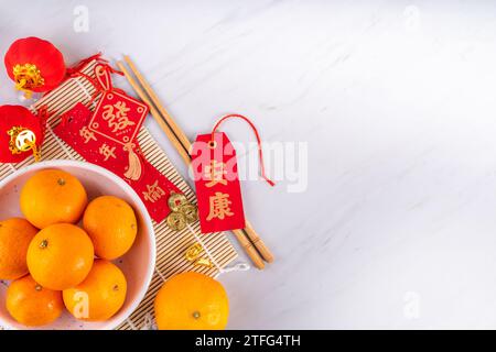 Chinesisches Neujahrsthintergrund mit Kopierraum. Rote Fans, Goldmünzen, Mandarinen, Kirschblüten, goldene Weihnachtszweige, Einrichtung, auf Wunsch Umschläge Stockfoto