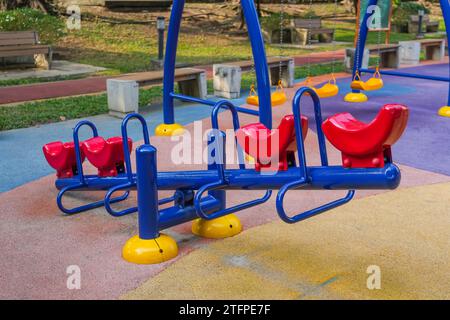 Blaurote Schaukel auf einem Spielplatz in einem Stadtpark Stockfoto