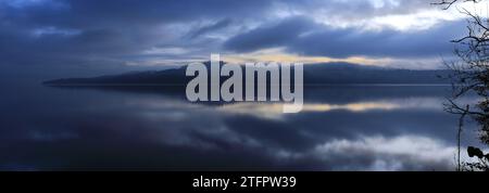 Ein nebeliger Sonnenaufgang über Loch Lomond von Duck Bay, Balloch Village, West Dunbartonshire, Schottland, Großbritannien Stockfoto