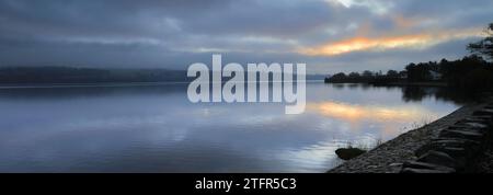 Ein nebeliger Sonnenaufgang über Loch Lomond von Duck Bay, Balloch Village, West Dunbartonshire, Schottland, Großbritannien Stockfoto