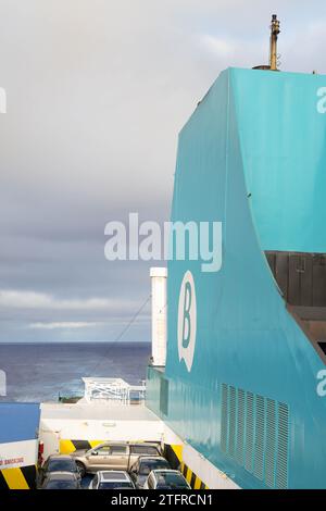 Große türkisfarbene Fähre mit markantem weißem Logo von Balearia. Die hoch aufragende Struktur des Schiffes vor dem Hintergrund eines bewölkten Himmels, der zum du übergeht Stockfoto