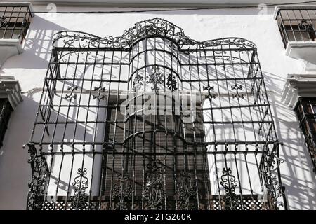 Balkon mit schmiedeeisernem Gitter an weiß getünchter Fassade in Ronda, Malaga, Spanien Stockfoto