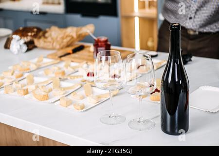 Vorbereitung der Weinprobe mit Käse-Paarungen. Der Sommelier bereitet sich auf eine Weinverkostung vor, bei der sorgfältig verschiedene Käsesorten mit Weinen kombiniert werden Stockfoto