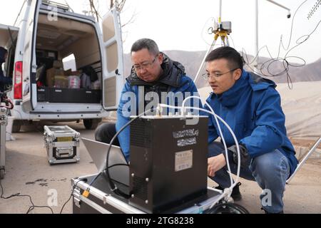 (231220) -- LINXIA, 20. Dezember 2023 (Xinhua) -- He Bo (L), ein Mitarbeiter des China Mobile Chengdu Institute of Research and Development, stellt Notfallkommunikationsgeräte mit seinem Kollegen an einem vorübergehenden Umzugsort im Dorf Dahe im Jishishan County, nordwestchinesische Provinz Gansu, am 20. Dezember 2023 ein. Laut einer Pressekonferenz am Mittwoch laufen umfassende Rettungs- und Hilfsarbeiten inmitten bitterer Kälte, da ein Erdbeben der Stärke 6,2 113 Menschen getötet und 782 weitere verletzt hat. Insgesamt waren 87.076 Menschen aus 20.457 Haushalten auf Zeit Stockfoto