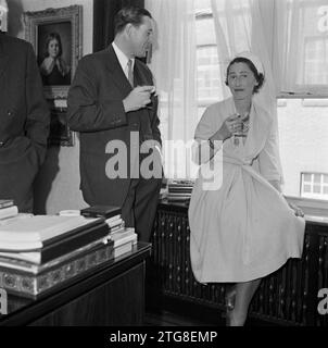 Mann, der mit einer Frau redet, während er einen Drink trinkt. 1950 Stockfoto