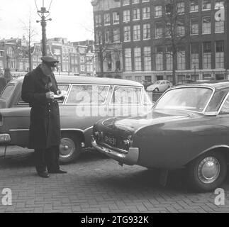 Blaue Zone zwischen Vijzelstraat und Leidsestraat auf einer ungeraden Seite, Parkwächter kontrolliert ca. April 1964 Stockfoto