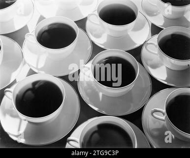 Getränkte Tassen (wahrscheinlich Kaffee) und Untertassen in Reihen, mit Schatten ca. Januar 1932 Stockfoto