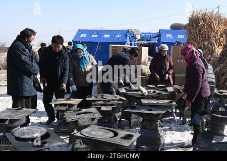 (231220) -- LINXIA, 20. Dezember 2023 (Xinhua) -- die Öfen werden an einem temporären Umzugsort im Dorf Shenjiaping im Jishishan County, nordwestchinesische Provinz Gansu, am 20. Dezember 2023 verteilt. Laut einer Pressekonferenz am Mittwoch laufen umfassende Rettungs- und Hilfsarbeiten inmitten bitterer Kälte, da ein Erdbeben der Stärke 6,2 113 Menschen getötet und 782 weitere verletzt hat. Insgesamt wurden 87.076 Menschen aus 20.457 Haushalten vorübergehend an sichere Orte verlegt. Notentlastungsmaterialien wie Zelte, Steppdecken, Klappbetten und feuchtigkeitsfeste Matte Stockfoto