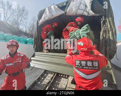 Linxia, Chinas Provinz Gansu. Dezember 2023. Mitglieder der Volksarmee (People's Armed Police Force, PAPF) transportieren Katastrophenhilfe im Dorf Cuijia in der Gemeinde Liuji, County Jishishan, nordwestchinesische Provinz Gansu, 20. Dezember 2023. Die chinesische Volksbefreiungsarmee (PLA) und die Volksarmee (PAPF) haben mehrere Rettungskräfte in Gebieten eingesetzt, die von Erdbeben betroffen sind, als Reaktion auf ein Erdbeben der Stärke 6,2, das die nordwestchinesische Provinz Gansu am späten Montag erschütterte. Quelle: An Pengfei/Xinhua/Alamy Live News Stockfoto