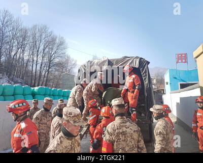 Linxia, Chinas Provinz Gansu. Dezember 2023. Mitglieder der Volksarmee (People's Armed Police Force, PAPF) transportieren Katastrophenhilfe im Dorf Cuijia in der Gemeinde Liuji, County Jishishan, nordwestchinesische Provinz Gansu, 20. Dezember 2023. Die chinesische Volksbefreiungsarmee (PLA) und die Volksarmee (PAPF) haben mehrere Rettungskräfte in Gebieten eingesetzt, die von Erdbeben betroffen sind, als Reaktion auf ein Erdbeben der Stärke 6,2, das die nordwestchinesische Provinz Gansu am späten Montag erschütterte. Quelle: Chen Jiale/Xinhua/Alamy Live News Stockfoto