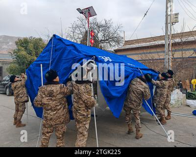 Linxia, Chinas Provinz Gansu. Dezember 2023. Mitglieder der Volksarmee (PAPF) stellten Zelte im Dorf Gaoli in der Gemeinde Liuji im Bezirk Jishishan in der nordwestlichen chinesischen Provinz Gansu auf, 20. Dezember 2023. Die chinesische Volksbefreiungsarmee (PLA) und die Volksarmee (PAPF) haben mehrere Rettungskräfte in Gebieten eingesetzt, die von Erdbeben betroffen sind, als Reaktion auf ein Erdbeben der Stärke 6,2, das die nordwestchinesische Provinz Gansu am späten Montag erschütterte. Quelle: Wang Yiwei/Xinhua/Alamy Live News Stockfoto