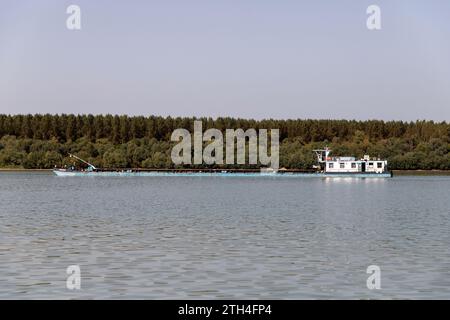 Ein Binnenschiff, das die Donau hinunterfährt Stockfoto