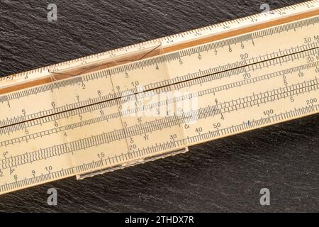 Ein logarithmisches Lineal auf Schieferstein, Makro, Draufsicht. Stockfoto